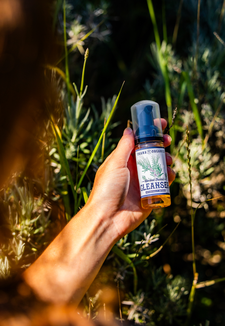 Ohana Organics facial cleanser being held in a hand outside